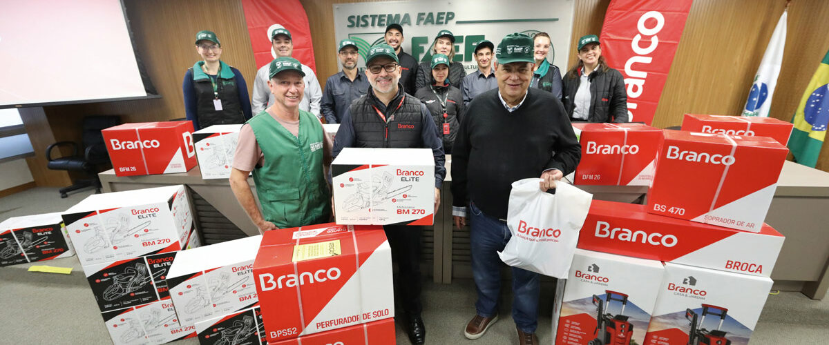 Doze pessoas com o boné verde do Sistema FAEP/SENAR-PR posam para a foto, com 18 caixas de equipamentos nas cores branca, vermelha e preta, da Branco Motores.