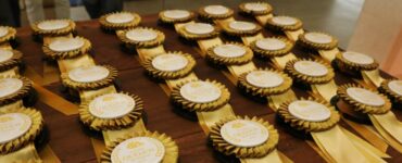 Medalhas de ouro do Prêmio Queijos do Paraná expostas em uma mesa.