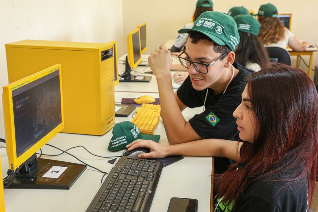 Alunos de colégio agrícola fazem atividade em computador, usando bonés do Sistema FAEP/SENAR-PR, parceiro para levar inovações tecnológicas para dentro dos centros de formação de técnicos agrícolas