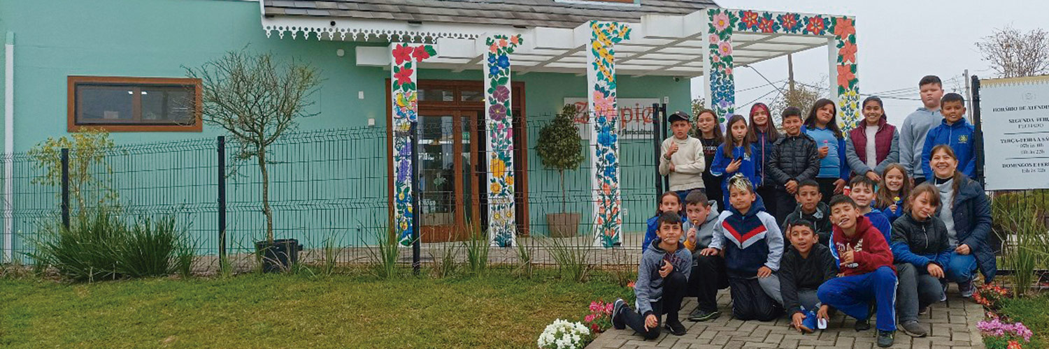 Alunos da professora Nilva Graboski posam para foto em frente a memorial da cultura polonesa