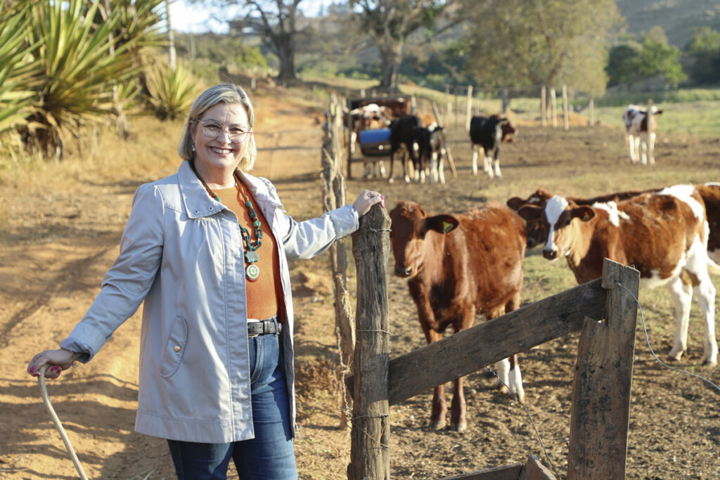 Deputada federal por Minas Gerais Ana Paula Leão em propriedade rural, com bezerros ao fundo