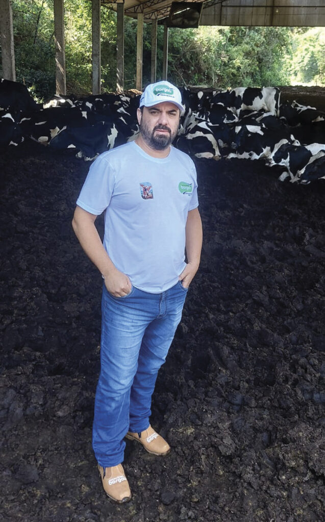 Douglas Oliveira posa para foto dentro do barracão onde ficam as vacas, em propriedade rural em Itapejara d'Oeste, voltada à produção de leite