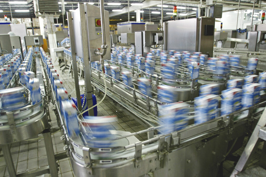 Imagem mostra indústria de leite em processo de engarrafamento de caixinhas do produto tipo longa vida