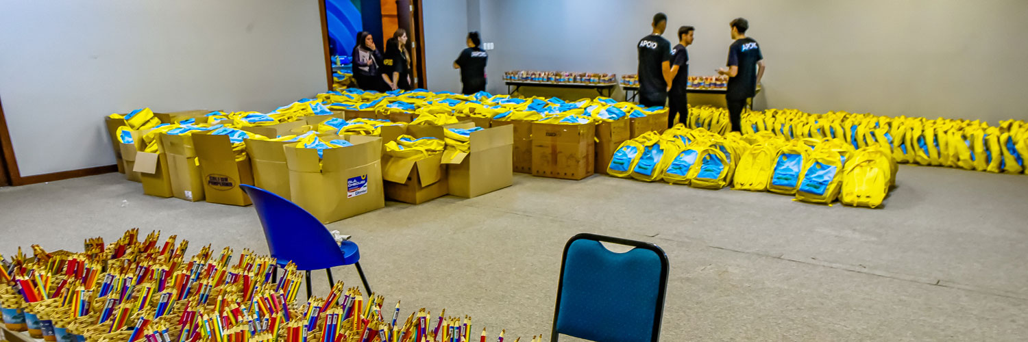 Colaboradores do Sistema FAEP/SENAR-PR organizam kits a serem distribuídos para participantes do encerramento do Programa Agrinho 2023 em uma sala do Expotrade, em Pinhais