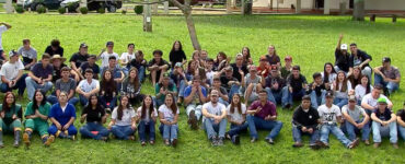 Frame do programa de TV Globo Rural no qual aparecem dezenas de estudantes de colégio agrícola de Castro sentados na grama lado a lado